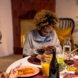 Doi prieteni care stau de vorbă la o cafea, pe o terasă, după o perioadă în care nu s-au mai văzut