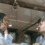 Două persoane într-o conversație profundă la o masă lângă fereastră, ascultându-se cu atenție
